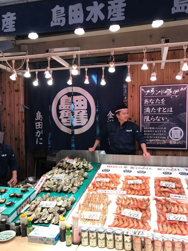 Seafood seller and stall at Omicho Market in Kanazawa, Japan.