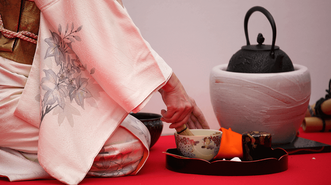 A female host prepares matcha at a traditional tea ceremony in Japan A female host prepares matcha at a traditional tea ceremony in Japan