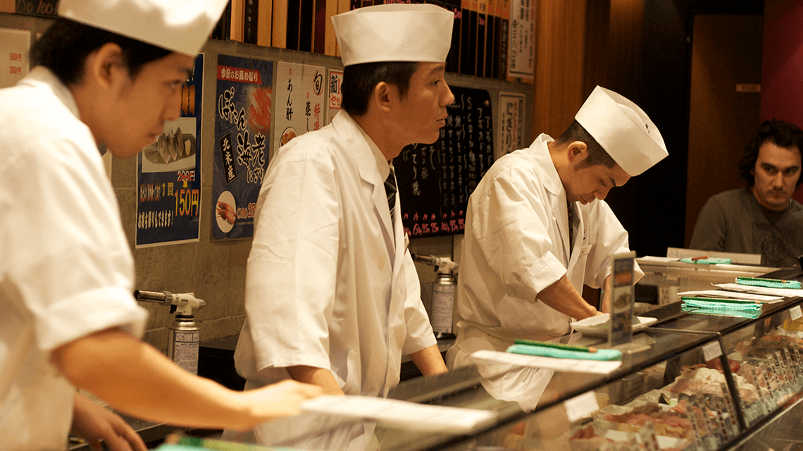 Chefs serving customers at a sushi bar in Shibuya, Tokyo, Japan Chefs serving customers at a sushi bar in Shibuya, Tokyo, Japan