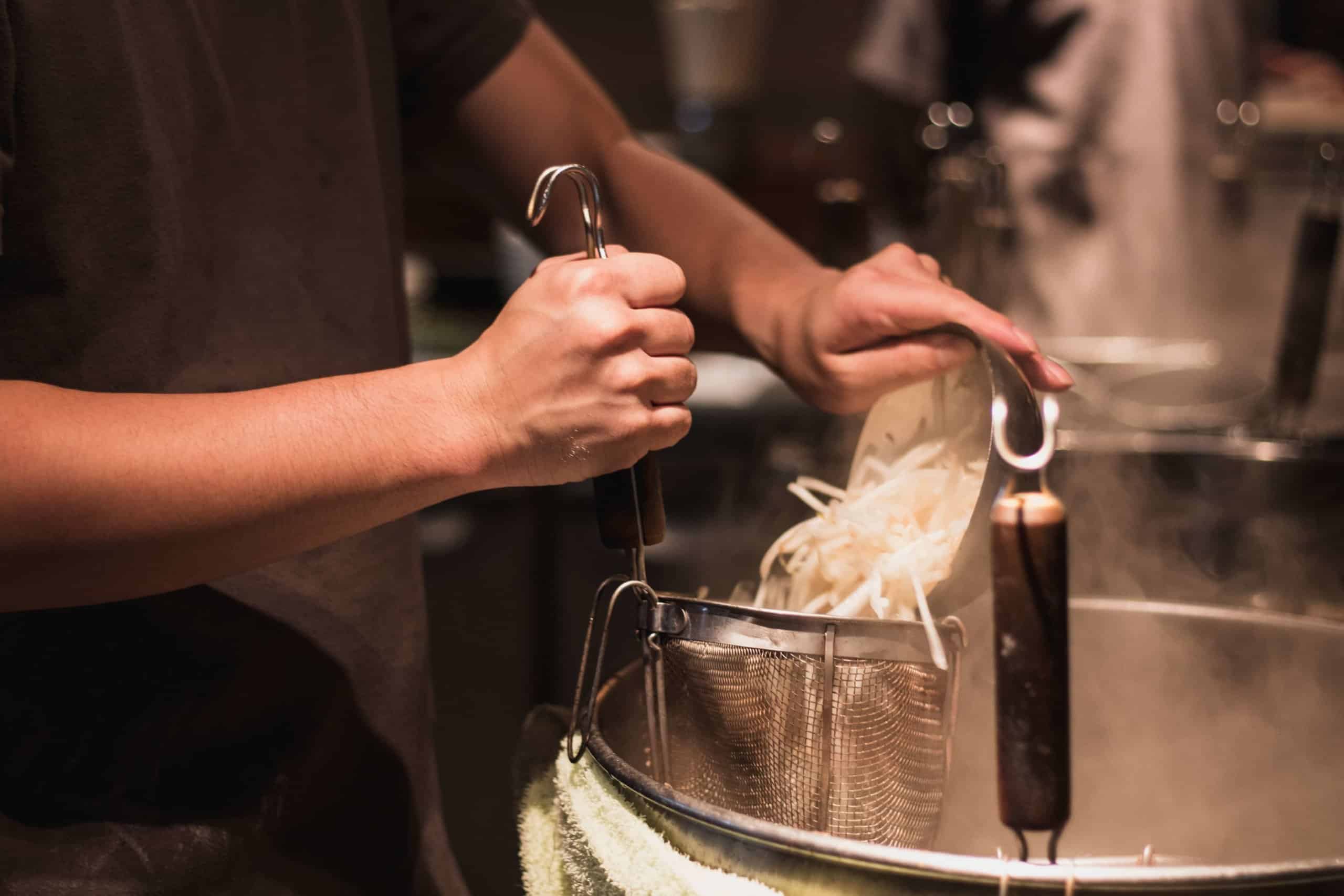 preparing ramen noodles at a ramenya in tokyo, japan