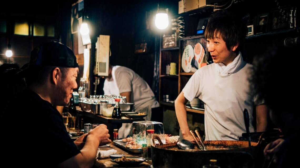 Chef and diner at a casual izakaya, or tavern, in Japan